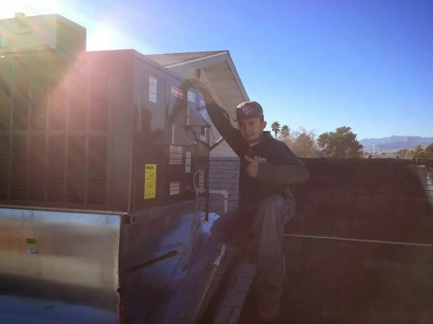 HVAC technician performing HVAC Inspection on a rooftop unit in Willis
